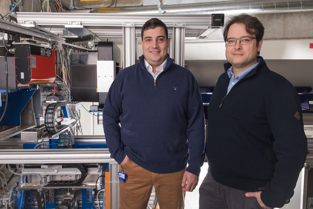 Die beiden PSI-Forscher Christian Grünzweig (links) und David Mannes an dem Experimentieraufbau mit Neutronenstrahlen, an dem die Durchleuchtungsbilder der Fertigspritzen angefertigt wurden. (Foto: Paul Scherrer Institut/Mahir Dzambegovic)
