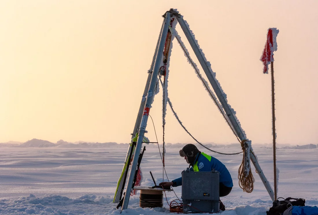A researcher setting up a measurement station in the Arctic