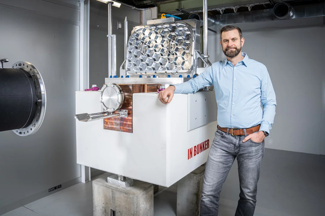 Marc Janoschek is leading the PSI project to build the ESTIA reflectometer at the European Spallation Source ESS. Here he stands at a component of the facility.