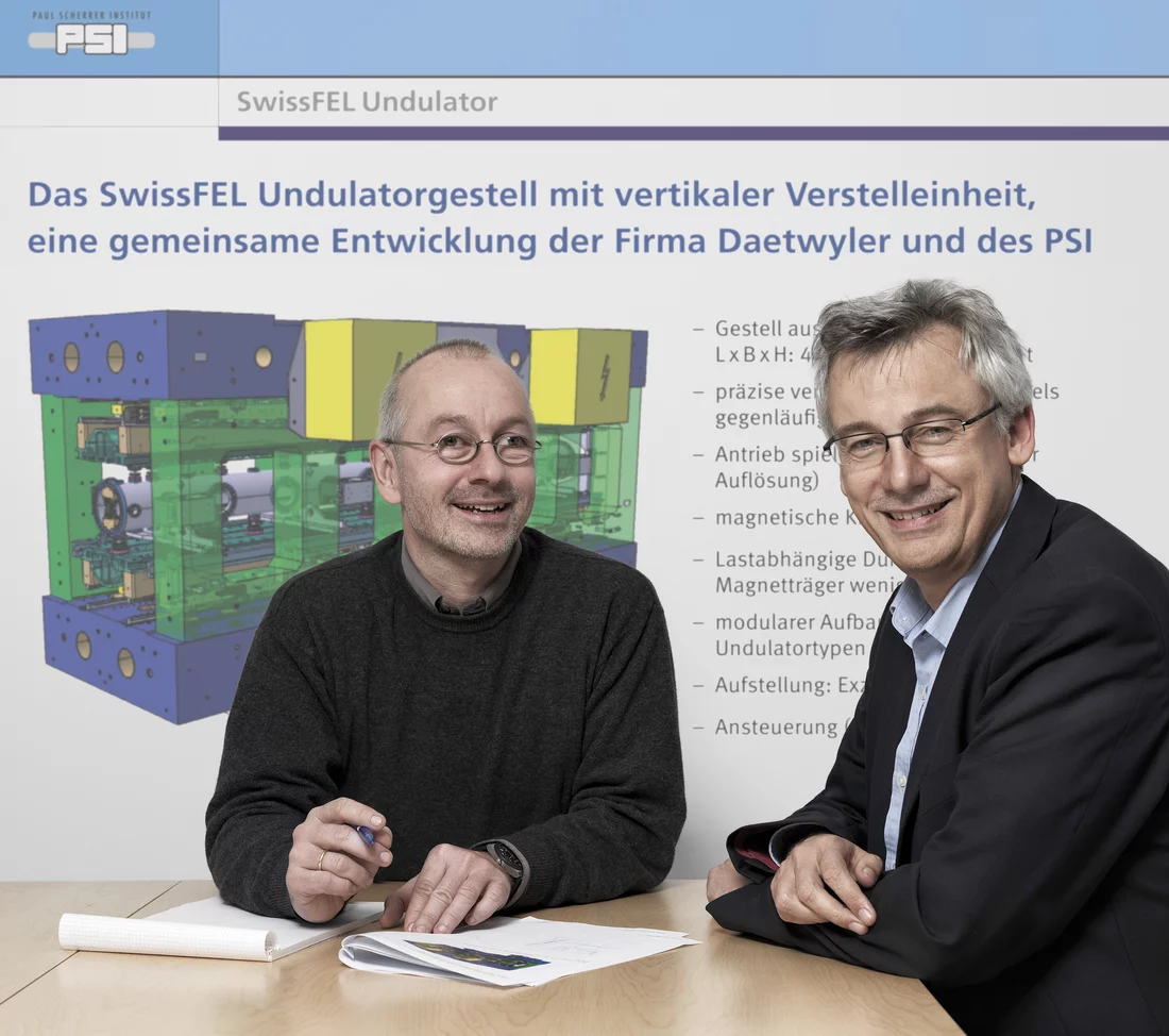 Thomas Schmidt, Leiter Undulatorentwicklung, und Hans Braun, SwissFEL-Projektleiter vor einer technischen Zeichnung des geplanten Undulators. (Scanderbeg Sauer Photography)