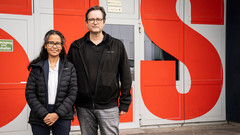 Margie Olbinado und David Mannes vor dem Eingang zur Synchrotron Lichtquelle Schweiz SLS, in der die Untersuchungen mit Synchrotronlicht durchgeführt wurden. In unmittelbarer Nachbarschaft dazu liegt auf dem Gelände des PSI die Schweizer Spallations-Neutronenquelle SINQ, die Neutronen für weitere Analysen liefert.
